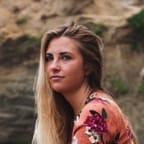 Emily posing for a photograph infront of a cropped section of a mountain