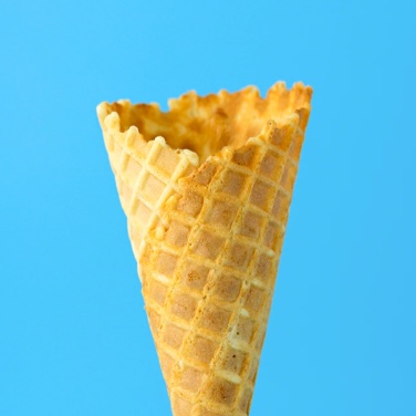 Empty ice-cream cone in front of a sky-blue background